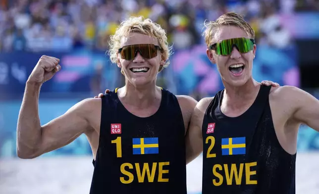 Sweden's David Ahmad, left, and Jonatan Hellvig strike a celebratory pose after defeating Brazil in a quarterfinal beach volleyball match at the 2024 Summer Olympics, Tuesday, Aug. 6, 2024, in Paris, France. (AP Photo/Robert F. Bukaty)