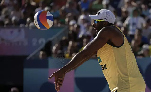 Brazil's Evandro Goncalves Oliveira Junior hits the ball during the men's quarterfinal beach volleyball match between Brazil and Sweden at Eiffel Tower Stadium at the 2024 Summer Olympics, Tuesday, Aug. 6, 2024, in Paris, France. (AP Photo/Louise Delmotte)