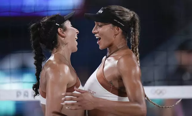 Canada's Brandie Wilkerson, right, and Melissa Humana-Paredes talk during the women's beach volleyball gold medal match between Brazil and Canada, at the 2024 Summer Olympics, Friday, Aug. 9, 2024, in Paris, France. (AP Photo/Louise Delmotte)