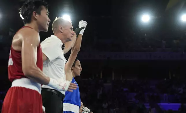 Algeria's Imane Khelif defeats Thailand's Janjaem Suwannapheng, left, in their women's 66 kg semifinal boxing match at the 2024 Summer Olympics, Tuesday, Aug. 6, 2024, in Paris, France. (AP Photo/John Locher)