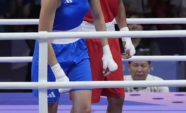 Algeria's Imane Khelif, red, next to Italy's Angela Carini, at the end of their women's 66kg preliminary boxing match at the 2024 Summer Olympics, Thursday, Aug. 1, 2024, in Paris, France. (AP Photo/John Locher)