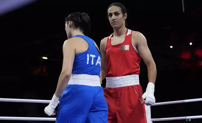 Algeria's Imane Khelif, right, walks beside Italy's Angela Carini after their women's 66kg preliminary boxing match at the 2024 Summer Olympics, Thursday, Aug. 1, 2024, in Paris, France. (AP Photo/John Locher)