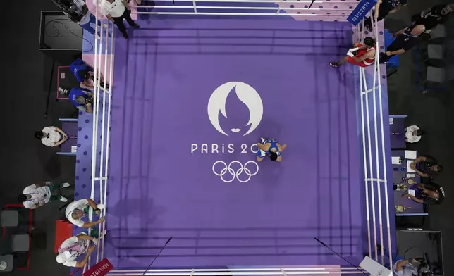 Italy's Angela Carini, center, reacts after she abandoned her fight against Algeria's Imane Khelif in their women's 66kg preliminary boxing match at the 2024 Summer Olympics, Thursday, Aug. 1, 2024, in Paris, France. (AP Photo/John Locher)