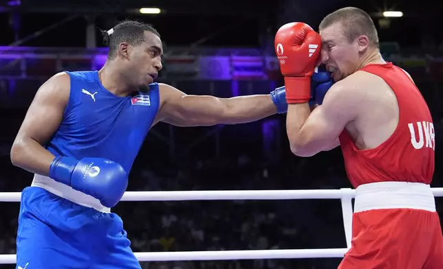 Cuba's Arlen Lopez hits Ukraine's Oleksandr Khyzhniak in their men's 80 kg semifinal boxing match at the 2024 Summer Olympics, Sunday, Aug. 4, 2024, in Paris, France. (AP Photo/Ariana Cubillos)