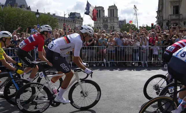 Nils Politt, of Germany, rides along with other cyclists past Notre Dame cathedral, visible in background, during the men's road cycling event, at the 2024 Summer Olympics, Saturday, Aug. 3, 2024, in Paris, France. (AP Photo/Dar Yasin)