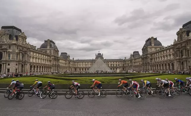 Cyclists ride past the Louvre museum as they compete in the men's road cycling event, at the 2024 Summer Olympics, Saturday, Aug. 3, 2024, in Paris, France. (AP Photo/Thibault Camus)