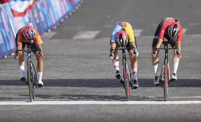 Silver medallist Marianne Vos, of the Netherlands, left, sprints ahead of Lotte Kopecky, of Belgium, centre, who clinched the bronze medal and Blanka Vas, of Hungary, during the women's road cycling event, at the 2024 Summer Olympics, Sunday, Aug. 4, 2024, in Paris, France. (AP Photo/Thibault Camus)