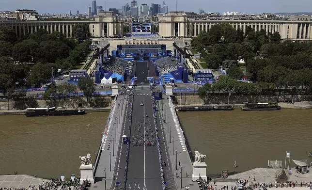 Athletes compete at the start of the women's road cycling event at the 2024 Summer Olympics, in Paris, France, Sunday, Aug. 4, 2024. (Huang Zongzhi/Pool Photo via AP)