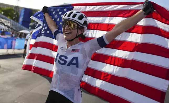 Kristen Faulkner, of the United States, celebrates winning the women's road cycling event, at the 2024 Summer Olympics, Sunday, Aug. 4, 2024, in Paris, France. (AP Photo/Thibault Camus)