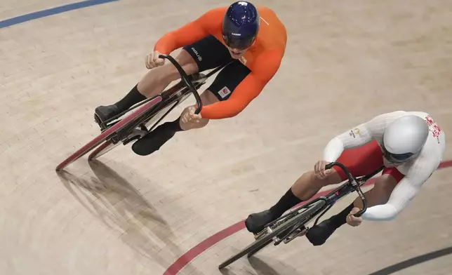 Harrie Lavreysen of Netherlands, left, competes alongside Mateusz Rudyk of Poland, during the men's sprint event, at the Summer Olympics, Thursday, Aug. 8, 2024, in Paris, France. (AP Photo/Thibault Camus)