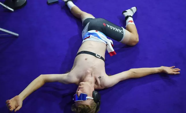 Carson Mattern of Canada stretches before competing in a track cycling event, at the 2024 Summer Olympics, Tuesday, Aug. 6, 2024, in Paris, France. (AP Photo/Thibault Camus)