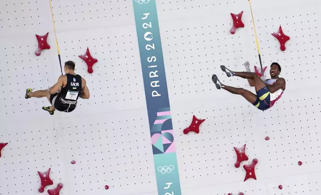 Bassa Mawem of France, right, reacts as he competes against Yaroslav Tkach of Ukraine in the men's speed, qualification elimination heats, during the sport climbing competition at the 2024 Summer Olympics, Tuesday, Aug. 6, 2024, in Le Bourget, France. (AP Photo/Tsvangirayi Mukwazhi)