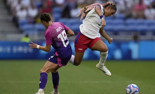 United States' Trinity Rodman fights for the ball with Germany's Felicitas Rauch during a women's semifinal soccer match between the United States and Germany at the 2024 Summer Olympics, Tuesday, Aug. 6, 2024, at Lyon Stadium in Decines, France. (AP Photo/Silvia Izquierdo)