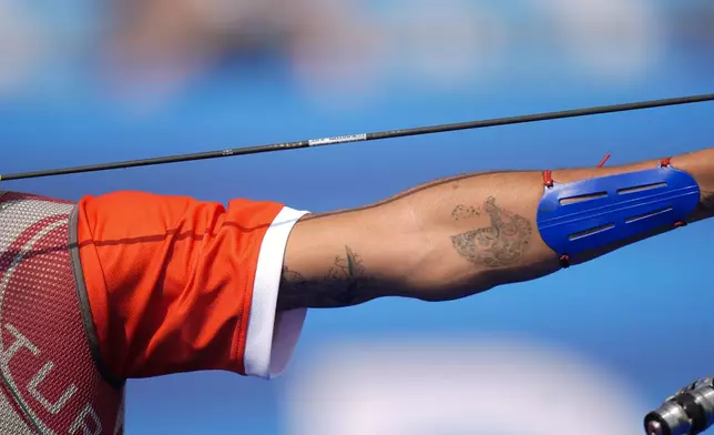 Turkey's Mete Gazoz shows an olympics tattoo on his arm during the Archery team elimination round against Japan at the 2024 Summer Olympics, Friday, Aug. 2, 2024, in Paris, France. (AP Photo/Brynn Anderson)