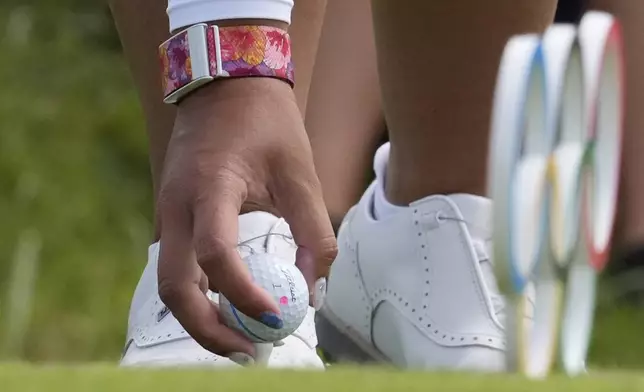 Lilia Vu, of the United States, places her ball on the tee on the 12th hole during the first round of the women's golf event at the 2024 Summer Olympics, Wednesday, Aug. 7, 2024, at Le Golf National, in Saint-Quentin-en-Yvelines, France. (AP Photo/George Walker IV)