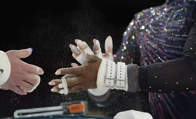 Simone Biles of the United States chalks up during a gymnastics training session at Bercy Arena at the 2024 Summer Olympics, Thursday, July 25, 2024, in Paris, France. (AP Photo/Abbie Parr)