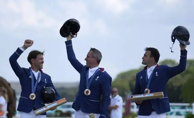 France's Simon Delestre, left, Julien Epaillard, center, and Olivier Perreau celebrate their bronze medals after the Equestrian Jumping Team final at the 2024 Summer Olympics, Friday, Aug. 2, 2024, in Versailles, France. (AP Photo/Mosa'ab Elshamy)