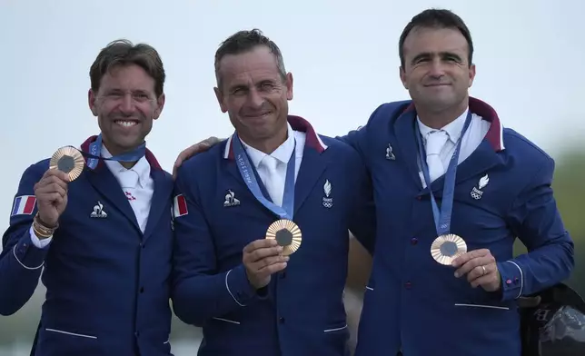 France's Simon Delestre, left, Julien Epaillard, center, and Olivier Perreau show their bronze medals after the Equestrian Jumping Team final at the 2024 Summer Olympics, Friday, Aug. 2, 2024, in Versailles, France. (AP Photo/Mosa'ab Elshamy)