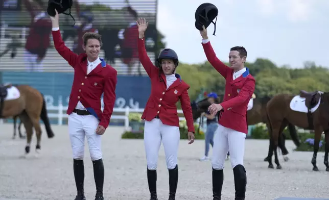 USA's Karl Cook, left, Laura Kraut, center, and McLain Ward celebrate after cpaturing the silver medal in the Equestrian Jumping Team final at the 2024 Summer Olympics, Friday, Aug. 2, 2024, in Versailles, France. (AP Photo/Mosa'ab Elshamy)