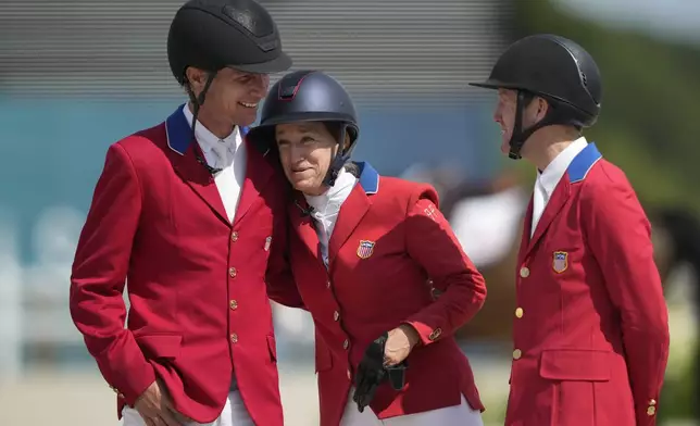 USA's Karl Cook, left, Laura Kraut, center, and McLain Ward react after cpaturing the silver medal in the Equestrian Jumping Team final at the 2024 Summer Olympics, Friday, Aug. 2, 2024, in Versailles, France. (AP Photo/Mosa'ab Elshamy)