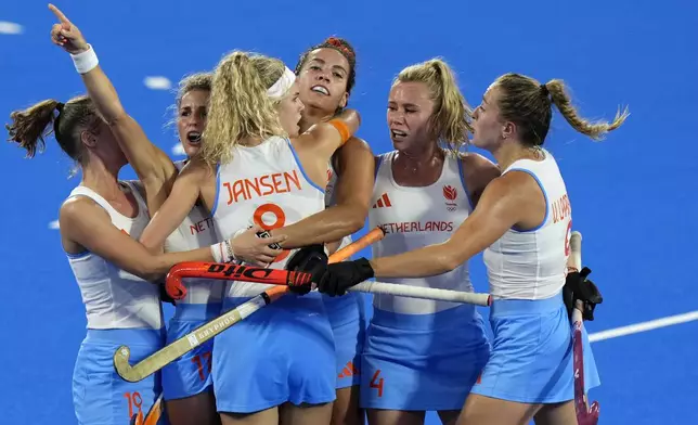 Netherlands' Yibbi Jansen, back to the camera, celebrates with teammates after scoring her side's first goal during the women's gold medal field hockey match between China and Netherlands at the Yves-du-Manoir Stadium during the 2024 Summer Olympics, Friday, Aug. 9, 2024, in Colombes, France. (AP Photo/Aijaz Rahi)