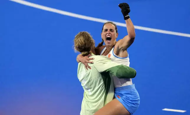 Netherlands' goalkeeper Anne Veenendaal carries teammate Pien Sanders, right, as they celebrate after winning the women's gold medal field hockey match against China at the Yves-du-Manoir Stadium during the 2024 Summer Olympics, Friday, Aug. 9, 2024, in Colombes, France. (AP Photo/Aijaz Rahi)
