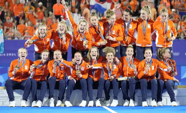 Team Netherlands poses for a photograph after winning the gold medal in the women's field hockey at the Yves-du-Manoir Stadium during the 2024 Summer Olympics, Friday, Aug. 9, 2024, in Colombes, France. (AP Photo/ Anjum Naveed)