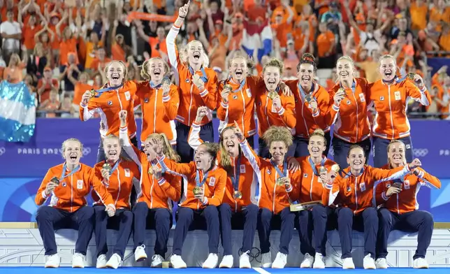 Team Netherlands poses for a photograph after winning the gold medal in the women's field hockey at the Yves-du-Manoir Stadium during the 2024 Summer Olympics, Friday, Aug. 9, 2024, in Colombes, France. (AP Photo/ Anjum Naveed)