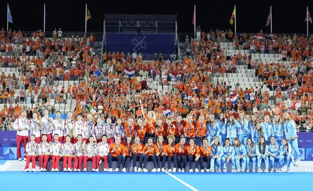 Team Netherlands, center, team China, left, and team Argentina pose for a photograph after winning the gold, silver and the bronze medals respectively in the women's field hockey at the Yves-du-Manoir Stadium during the 2024 Summer Olympics, Friday, Aug. 9, 2024, in Colombes, France. (AP Photo/ Anjum Naveed)