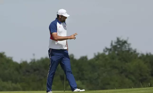 Scottie Scheffler, of the United States, reacts to the crowd after making a birdie on the 19th green during the final round of the men's golf at the 2024 Summer Olympics, Sunday, Aug. 4, 2024, at Le Golf National in Saint-Quentin-en-Yvelines, France. (AP Photo/Matt York)