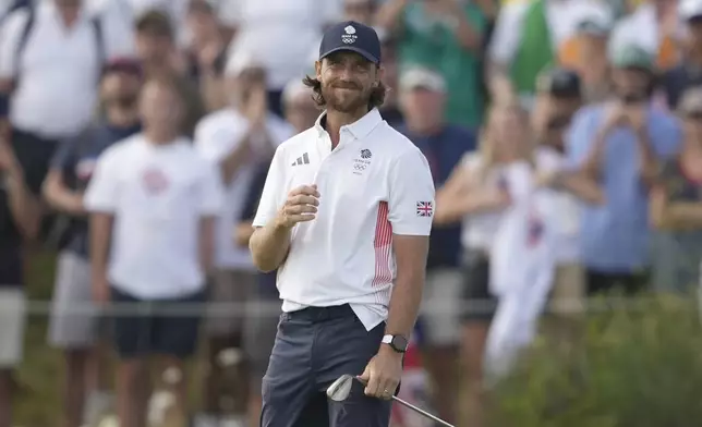 Tommy Fleetwood, of Britain, react after playing a chip shot onto the 18th green during the final round of the men's golf at the 2024 Summer Olympics, Sunday, Aug. 4, 2024, at Le Golf National in Saint-Quentin-en-Yvelines, France. Scottie Scheffler, of the United States, wins the gold medal with Tommy Fleetwood, of Britain, silver and Hideki Matsuyama, of Japan, the bronze. (AP Photo/Matt York)