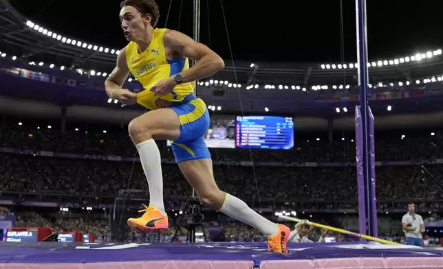 Armand Duplantis, of Sweden, celebrates after setting a new world record in the men's pole vault final at the 2024 Summer Olympics, Monday, Aug. 5, 2024, in Saint-Denis, France. (AP Photo/Bernat Armangue)