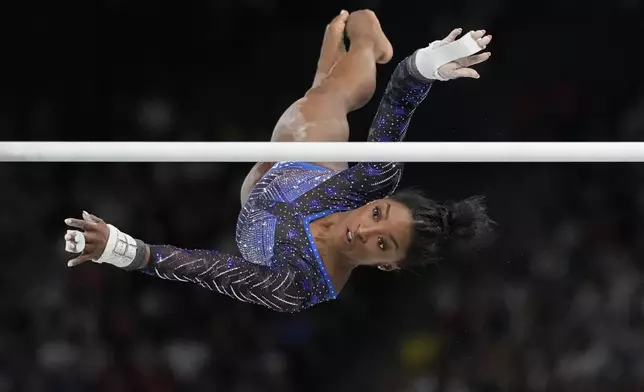 Simone Biles, of the United States, performs on the uneven bars during the women's artistic gymnastics all-around finals in Bercy Arena at the 2024 Summer Olympics, Thursday, Aug. 1, 2024, in Paris, France. (AP Photo/Natacha Pisarenko)