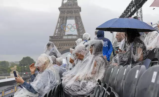 Spectators wait for the start of the opening ceremony of the 2024 Summer Olympics in Paris, France, Friday, July 26, 2024. (AP Photo/Thibault Camus)