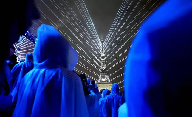 Flashes of lights illuminate the Eiffel Tower in Paris, France, during the opening ceremony of the 2024 Summer Olympics, Friday, July 26, 2024. (AP Photo/Robert F. Bukaty)