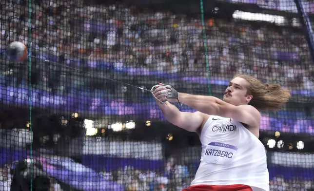 Ethan Katzberg, of Canada, makes an attempt in the men's hammer throw qualification at the 2024 Summer Olympics, Friday, Aug. 2, 2024, in Saint-Denis, France. (AP Photo/Matthias Schrader)