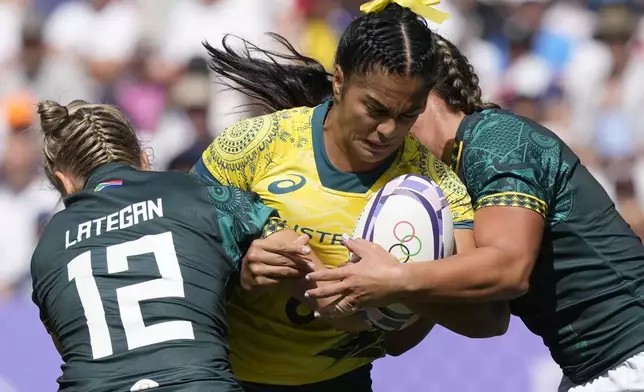 Australia's Sarah Maki is tackled by South Africa's Liske Lategan, left, during the women's Pool B Rugby Sevens match between Australia and South Africa at the 2024 Summer Olympics, in the Stade de France, in Saint-Denis, France, Sunday, July 28, 2024. (AP Photo/Tsvangirayi Mukwazhi)