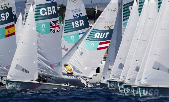 A fleet of boats compete in the 470 mixed dinghy race during the 2024 Summer Olympics, Tuesday, Aug. 6, 2024, in Marseille, France. (AP Photo/Carolyn Kaster)