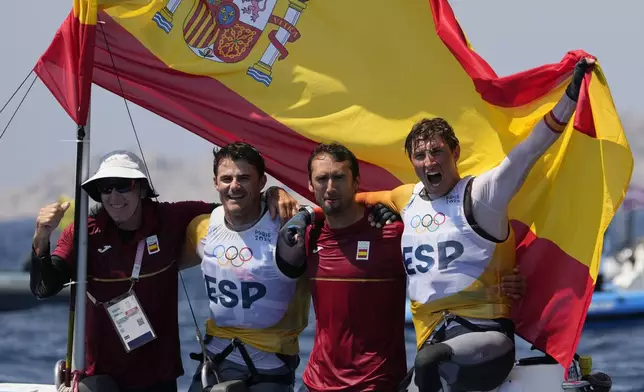 Florian Trittel Paul and Diego Botin Le Chever of Spain celebrate clinching the gold medal in the men's skiff race, at the 2024 Summer Olympics, Friday, Aug. 2, 2024, in Marseille, France. (AP Photo/Jacquelyn Martin)