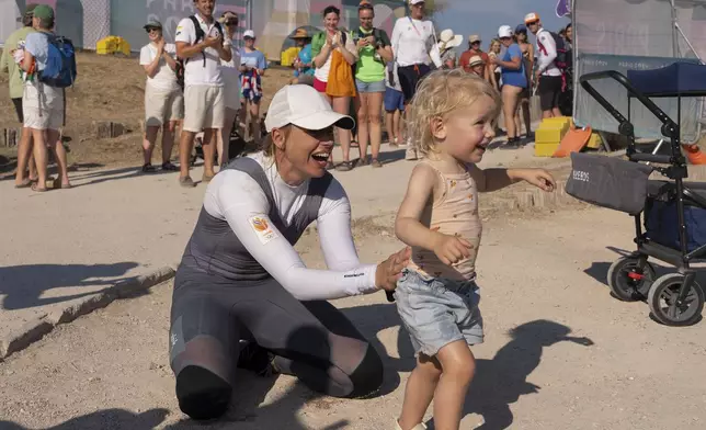 Marit Bouwmeester of the Netherlands celebrates with her daughter Jessie Mae after competing in ILCA 6 dinghy class racing during the 2024 Summer Olympics, Monday, Aug. 5, 2024, in Marseille, France. (AP Photo/Carolyn Kaster)