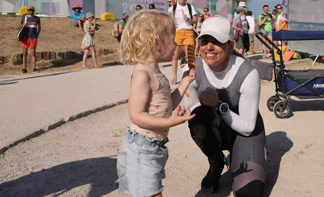 Marit Bouwmeester of the Netherlands celebrates with her daughter Jessie Mae after competing in ILCA 6 dinghy class racing during the 2024 Summer Olympics, Monday, Aug. 5, 2024, in Marseille, France. (AP Photo/Carolyn Kaster)