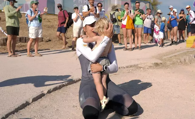 Marit Bouwmeester of the Netherlands celebrates with her daughter Jessie Mae after competing in ILCA 6 dinghy class racing during the 2024 Summer Olympics, Monday, Aug. 5, 2024, in Marseille, France. (AP Photo/Carolyn Kaster)