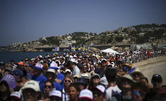 Fans watch the women's skiff race on a screen at the Olympic marina during the 2024 Summer Olympics, Friday, Aug. 2, 2024, in Marseille, France. (AP Photo/Daniel Cole)