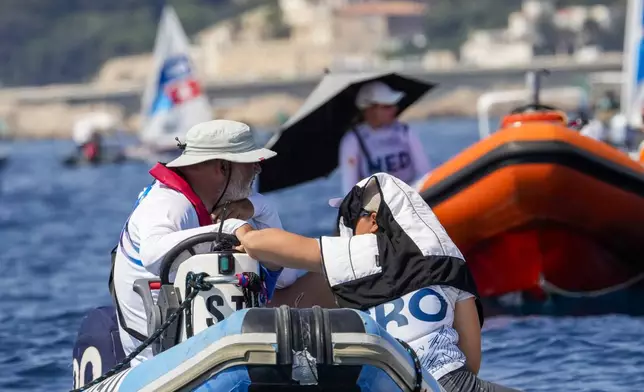 Elena Vorobeva of Croatia, right, talks to her coach as they wait for the start of the ILCA 6 dinghy class final race during the 2024 Summer Olympics, Tuesday, Aug. 6, 2024, in Marseille, France. (AP Photo/Jacquelyn Martin)