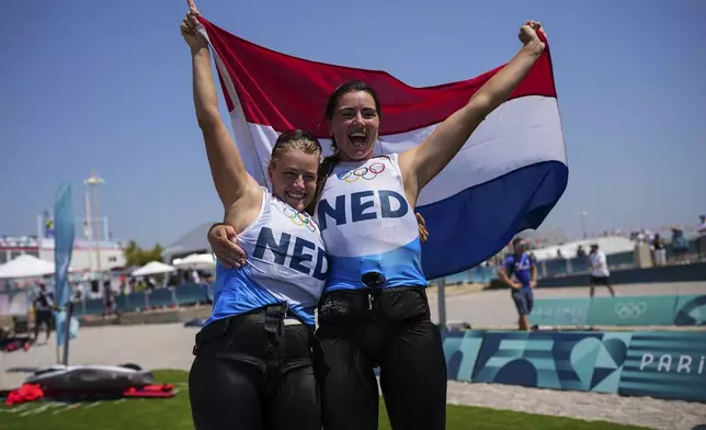 Annette Duetz, right, and Odile Aanholt of the Netherlands celebrate winning the gold medal in the women's skiff race at the Olympic marina during the 2024 Summer Olympics, Friday, Aug. 2, 2024, in Marseille, France. (AP Photo/Daniel Cole)