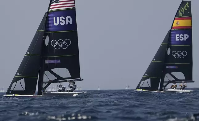 Ian Barrows and Hans Henken of the United States, left, and Florian Trittel Paul and Diego Botin Le Chever of Spain compete in a men's skiff race, at the 2024 Summer Olympics, Friday, Aug. 2, 2024, in Marseille, France. (AP Photo/Jacquelyn Martin)