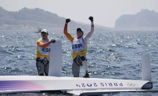 Florian Trittel Paul and Diego Botin Le Chever of Spain celebrate clinching the gold medal in the men's skiff race, at the 2024 Summer Olympics, Friday, Aug. 2, 2024, in Marseille, France. (AP Photo/Jacquelyn Martin)