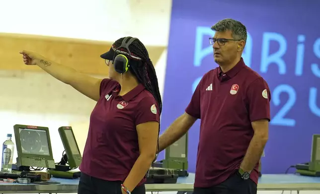 Turkey's Sevval Ilayda Tarhan, left, and teammate Yusuf Dikec prepare to compete in the 10m air pistol mixed team qualification round at the 2024 Summer Olympics, Monday, July 29, 2024, in Chateauroux, France. (AP Photo/Manish Swarup)