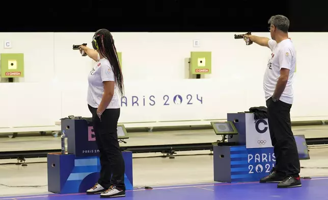 Turkey's Savval Ilayda Tarhan, left, and Yususf Dikec compete in the 10m air pistol mixed team gold medal event at the 2024 Summer Olympics, Tuesday, July 30, 2024, in Chateauroux, France. (AP Photo/Manish Swarup)