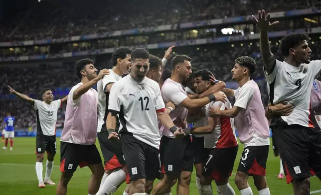 Egypt's players celebrate their side's opening goal scored by teammate Mahmoud Saber during the men's semifinal soccer match between France and Egypt, at Lyon Stadium, during the 2024 Summer Olympics, Monday, Aug. 5, 2024, in Decines, France. (AP Photo/Silvia Izquierdo)